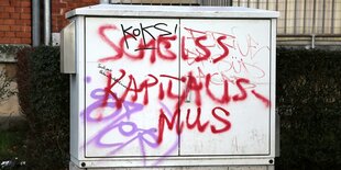 Auf einemn Stromkasten ist der Slogan "Scheiss Kapitalismus" aus roter Farbe zu lesen