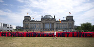 rotes Plakat "cross borders not lines" in schwarzer Schrift vor dem Reichstag