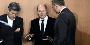 Drei Männer in schwarzen Anzügen stehen beisammen: Habeck, Scholz und Lindner