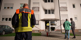 Im Hintergrund die Heppenheimer Flüchtlingsunterkunft, in der es gebrannt hat. Im Vordergrund ein Feuerwehrmann.