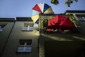 Das Foto zeigt einen Wohnungsbalkon mit Sonnenschirm.