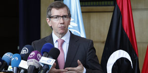Der libysche UNO-Gesandte Bernardino Leon an einem Rednerpult mit Mikrofonen.
