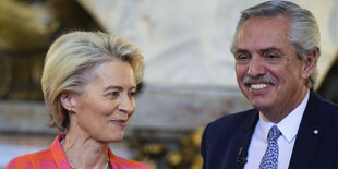 Nahaufnahme von von der Leyen, die schmunzelt, und Argentiniens Präsident, der grinst