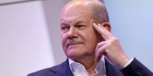 Olaf SCholz vor lavendelfarbenem Hintergrund