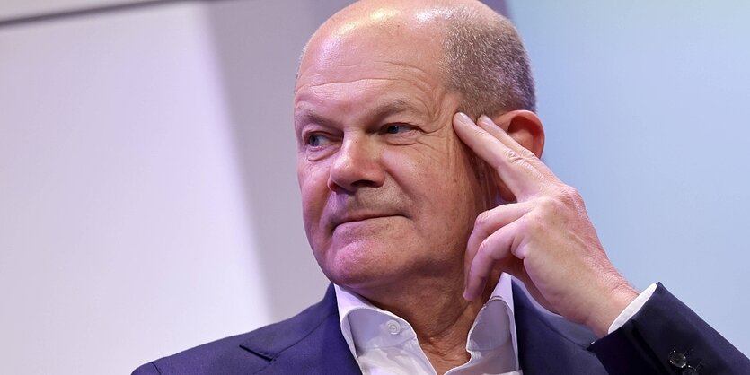 Olaf SCholz vor lavendelfarbenem Hintergrund