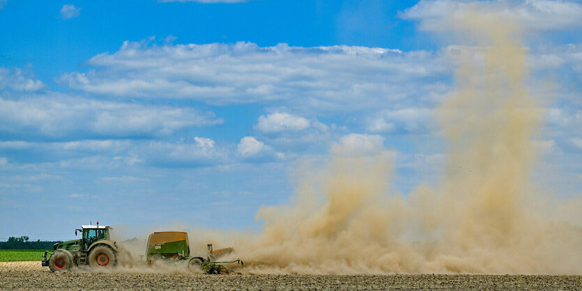 Ein Traktor wirbelt viel Staub auf