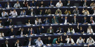 Menschen im EU-Parlament, einige heben ihre Hände