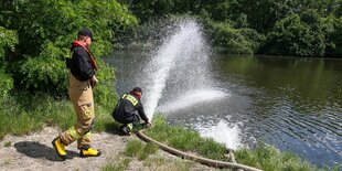 Feueerwehrmänner im Einsatz an einem Gewässer