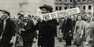 Ein Mann in einer Menschenmenge trägt eine Schild auf seinen Schultern mit der Aufschritft "Ende des Demokratischen"