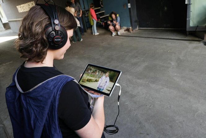 Theaterbesucher schaut ein Video auf dem Tablet