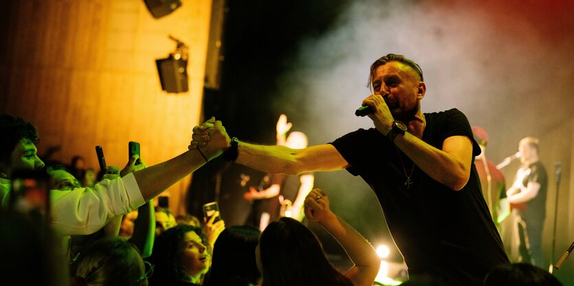 Serhij Zhadan schüttelt beim Konzert im Haus der Berliner Festspiele einem Fan die Hand.