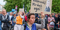 Ein Demonstrant hält ein Schild mit der Aufschrift "10 - 20 Tote Fahrradfahrende? Mir doch egal" und einem Bild von Manja Schreiner