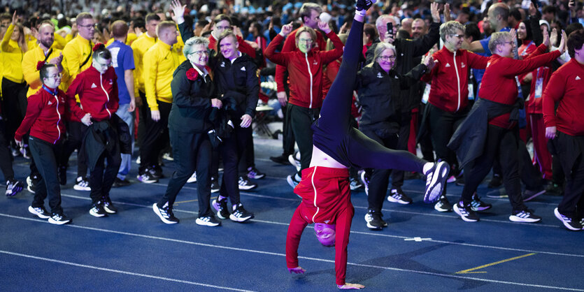 Eine Person macht Handstand im Olympiastadion