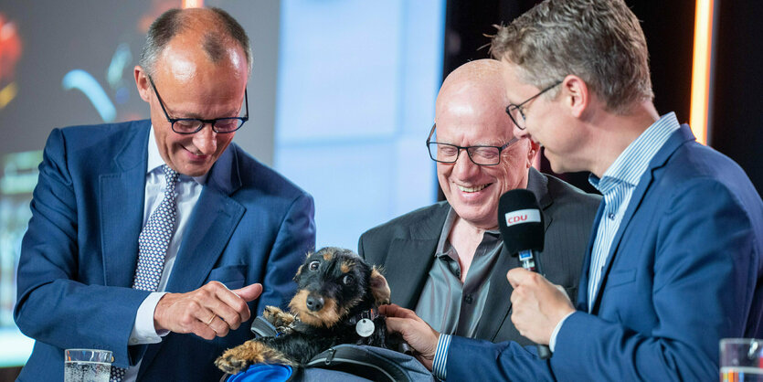 Merz streichelt einen Dackel, Ralf Fücks und Carsten Linnemann lachen darüber