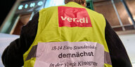 Mann mit Verdi-Streikweste vor dem Kino International. Auf der Weste steht: "13-14 Euro Stundenlohn demnächst in der Yorck-Kinogruppe"