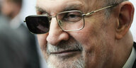 Der Schriftsteller Salman Rushdie mit einsetig verdunkelter Brille