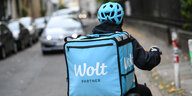 Eine Fahrradkurierin ist für den Essenslieferdienst Wolt, ein finnisches Startup, in einer Straße in Berlin-Mitte unterwegs.