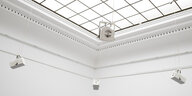 Blick auf Installation "Holy Water", vier weiße Lautsprecher an der Decke eines weißen Museumssaals
