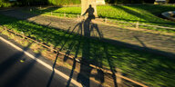 Radfahrer wirft einen Schatten ins Grün