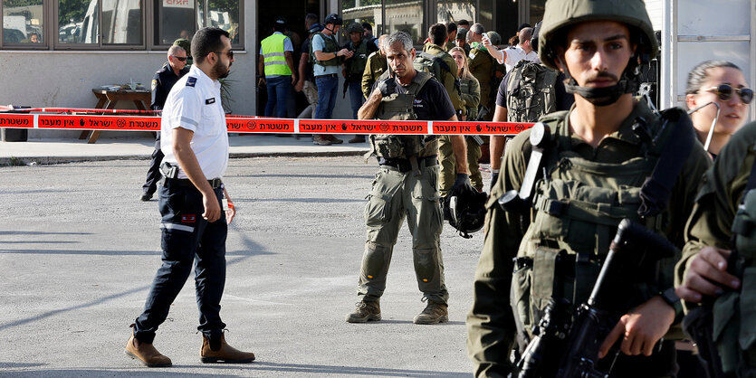 Männer in Uniformen und mit Waffen an einem Tatort