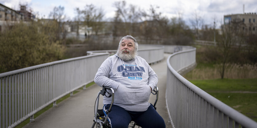 René Goldstein auf einem Rollator sitzend auf einer Brücke