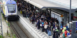 Überfüllter Bahnsteig, Zug fährt ein