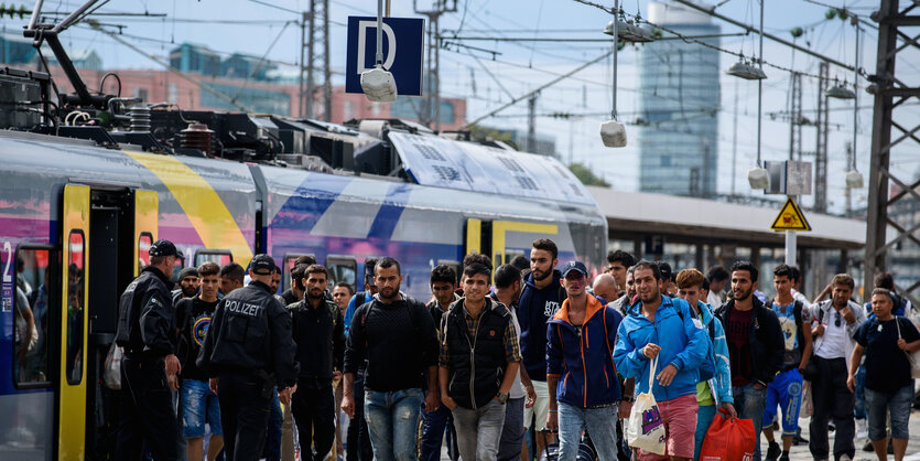 Menschen laufen einen Bahnsteig hinunter