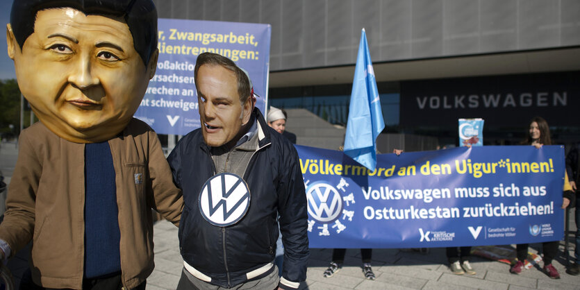 Demonstranten eines Aktionsbuendnis von Klimaaktivisten mit Masken von Staatsoberhaupt Chiun Xi Jinping und Oliver Blume