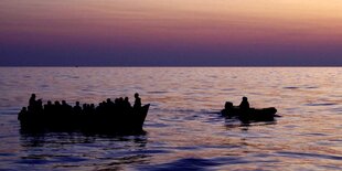 Ein Rettungsboot des Motorsegelschiffs "Nadir" begleitet ein überfülltes Stahlboot im Mittelmeer