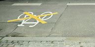 Ein mit gelben Markierungen durchgestrichenes Radwege-SYmbol