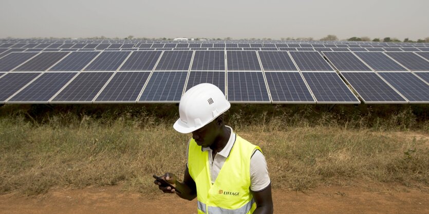 Ein Mann steht vor einer Solaranlage