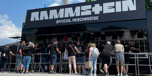 Eine Reihe Fans steht vor einem Rammstein-Stand