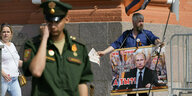 Mann hält pro-Putin Plakat in Moskau
