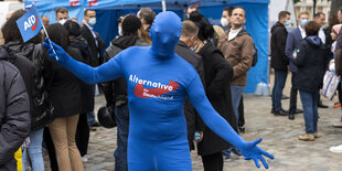 Ein Mann in einem engen Gnzkörperanzug mit AfD-Logo