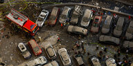 Ein Rettungswagen und viele mit Staub bedeckte und zerstörte Autos