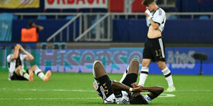 Gruppenbild mit Rasen: Yann Bisseck (v.) macht sich nach dem Abpfiff lang.