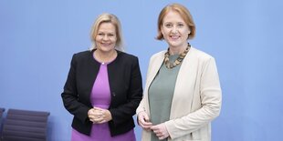 Nancy Faeser und Lisa Paus vor der baluen Wand der Bundespressekonferenz