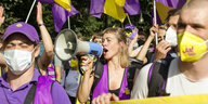 Menschen demonstrieren, sie tragen Fahnen der Initiative "Deutsche Wohnen Enteignen", eine Frau spricht in ein Megafon