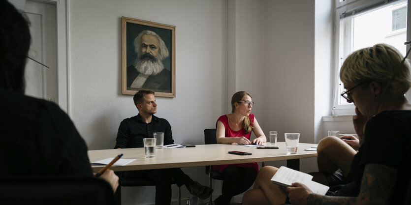 Franziska Brychcy und Maximilian Schirmer, Vorstand der Berliner Partei DIE LINKE, über den beiden hängt ein Portrait von Karl Marx.