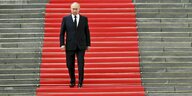 Putin schreitet auf einem roten Teppich eine Treppe herunter