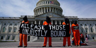 Demonstranten in orangen Anzügen vor dem Capitol