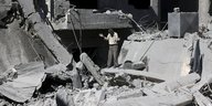 Ein Mann steht in den Trümmern eines Wohnhauses
