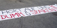 Ein Banner mit der Aufschrift "Hört auf uns dumm zu sparen" liegt auf dem Doberaner Platz in Rostock.