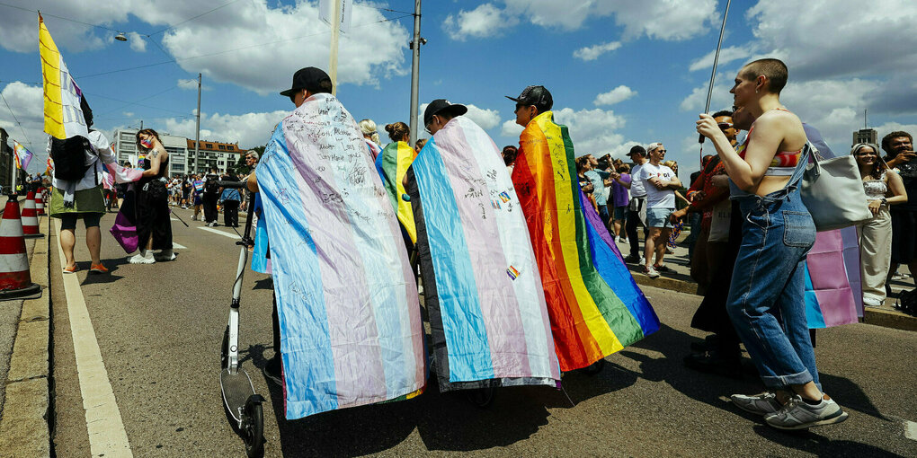 Teilnehmer laufen mit unterschiedichen Pride Fahnen auf dem CSD in München