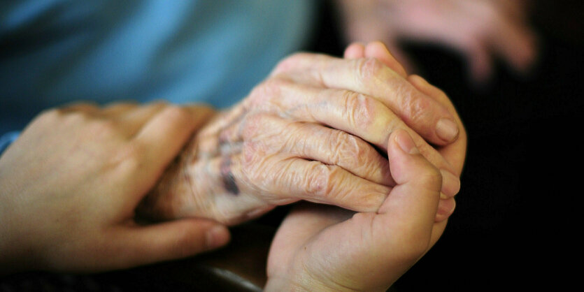 Die Hand einer Person liegt in den Händen einer anderen Person