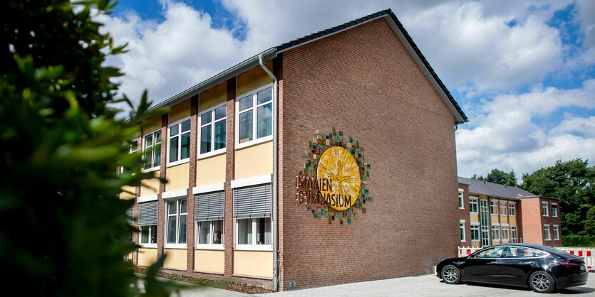 Das Logo der Schule und der Schriftzug "Mariengymnasium" hängen an einer Wand am Eingang der Schule in Papenburg