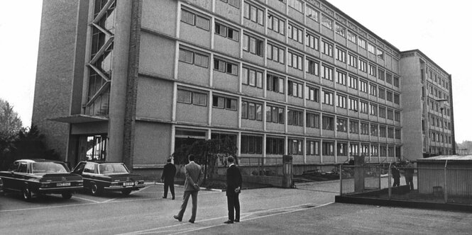 Hochhaus mit zwei Menschen davor: Das Gebäude des Bundesamtes für Verfassungsschutz in Köln