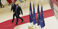 Zwischen die EU Fahnen sind Nato Fahnen gesteckt, Stoltenberg und Michel daran vorbei auf einem roten Teppich