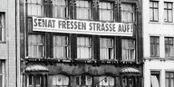 Ein Transparent mit der Aufschrift "Senat fressen Straße auf" hängt an der Fassade des Hauses Admiralität­straße 74.