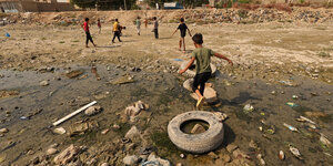 Kinder spielen in einem ausgetrockneten Flussbett